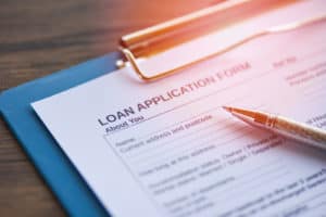 Loan application form with pen on paper / financial loan negotiation for lender and borrower on business document mortgage loan approval